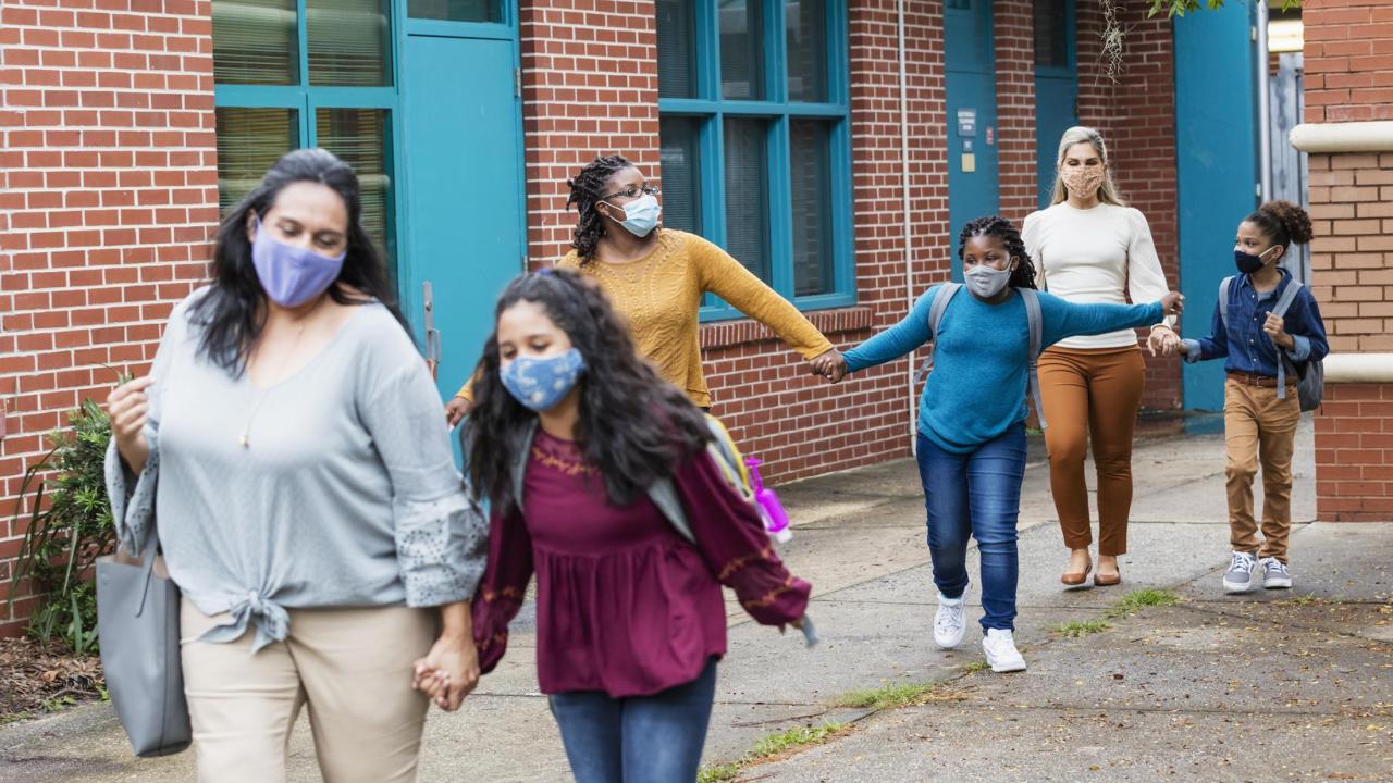 parents and children walking with masks on