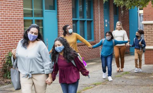 parents and children walking with masks on